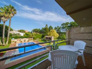 a balcony with a table and chairs and a swimming pool at Hotel Spa Atlántico San Vicente do Mar in San Vicente do Mar