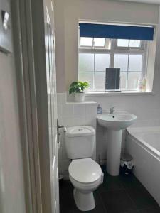 a bathroom with a toilet and a sink and a window at The Great Haxby City Centre Free Parking Cardiff Bay in Cardiff