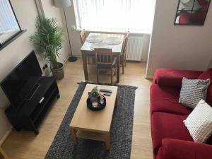 a living room with a red couch and a table at The Great Haxby City Centre Free Parking Cardiff Bay in Cardiff