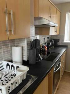 a kitchen with a black counter top with a dishwasher at The Great Haxby City Centre Free Parking Cardiff Bay in Cardiff
