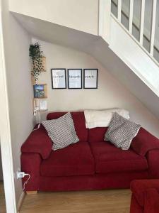 a red couch in a living room under a staircase at The Great Haxby City Centre Free Parking Cardiff Bay in Cardiff