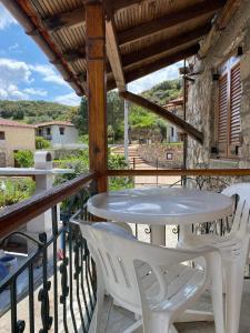 a patio with a table and chairs on a balcony at Despina’s House in Sykia Chalkidikis