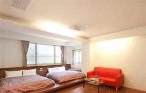 鹿谷的住宿－南投溪頭尚緹會館(民宿)，一间卧室配有两张床和红色椅子