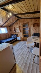 een kamer met een bank en tafels in een hut bij Domek przy promenadzie in Mikołajki