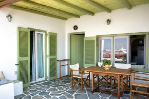 a patio with a wooden table and chairs at Tourlos Beachfront House in Mykonos in Tourlos