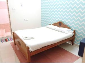 a small bed in a room with a wall at ECO VILLA in Puducherry