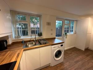 a kitchen with a sink and a washing machine at Comfortable 3 Bed House with Garden & Parking in Nottingham