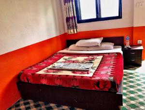 a bed in a room with a red wall at New Araniko Resort (P) Ltd in Chautara