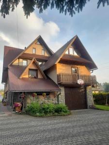une grande maison avec un toit brun dans l'établissement Nad Potokiem, à Poronin