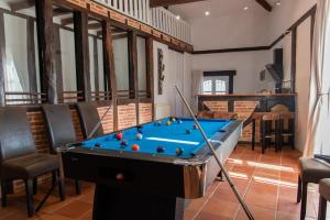 a pool table in a living room with a pool at Suites romantiques spa privatif, piscine, jardin, massages proche de Toulouse in Verfeil