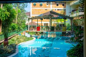 una piscina in un resort con gazebo di Golf Course Hotel a Kampala