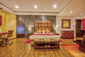 a bedroom with a large bed and a desk at Span Resort and Spa in Manāli