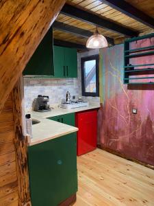 eine Küche mit grünen und roten Schränken und einem Fenster in der Unterkunft Bungalow In Iznik in İznik