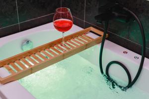 - un verre de vin rouge assis sur une baignoire dans l'établissement Incentro Domus, à Polignano a Mare