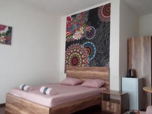 a bedroom with a bed with a painting on the wall at Guest House Buche on Agmashenebeli 219 in K'obulet'i