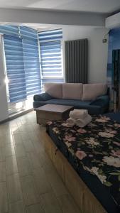 un soggiorno con divano e letto di Studio Alezzi Beach Resort Ely a Năvodari