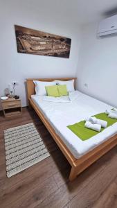 a bedroom with a large bed with two towels on it at Apartmani - Kladovski Konak in Kladovo