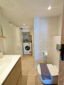a bathroom with a sink and a washing machine at Avramiou Loft Studio in Ágios Rókkos