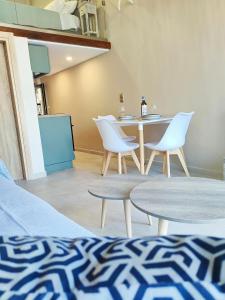 ein Wohnzimmer mit einem Tisch und Stühlen sowie eine Küche in der Unterkunft Avramiou Loft Studio in Ágios Rókkos