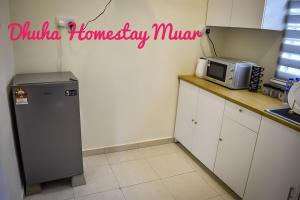 a small kitchen with a microwave and a counter at Dhuha Homestay Muar in Muar