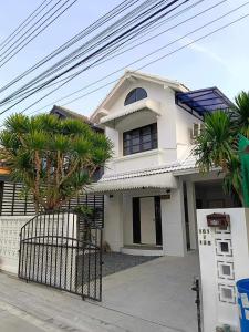 ein weißes Haus mit Palmen davor in der Unterkunft Cawleys house in Bang Phli