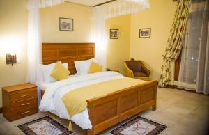a bedroom with a large bed and a chair at Cornerstone Villas in Arusha