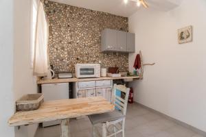 a small kitchen with a table and a microwave at Green Retreats 5 Paros in Isterni