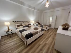 a bedroom with two beds and a table and lamps at Al Vicolo Stretto in Brancaleone Marina