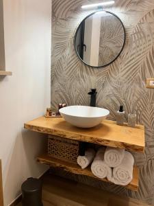 uma casa de banho com lavatório, espelho e toalhas em Al Vicolo Stretto em Brancaleone Marina