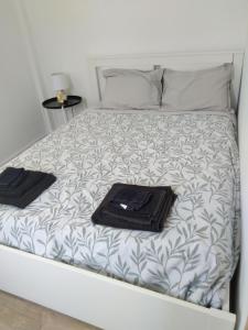 Una cama con dos toallas y una bandeja. en Casa Guti, en Costa da Caparica