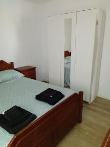 1 dormitorio con 1 cama con 2 toallas negras en Casa Guti, en Costa da Caparica