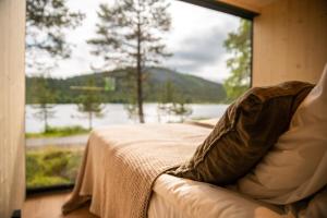 a couch in front of a window with a view of a lake at Kuuru Lakeside in Salla