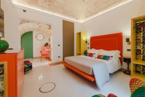 - une chambre avec un lit doté d'une tête de lit orange dans l'établissement Incentro Domus, à Polignano a Mare
