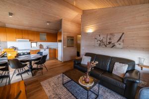 a living room with a couch and a table and a kitchen at Efsti-Dalur Cottages in Úthlid