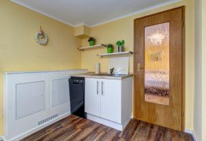 a kitchen with white cabinets and a black dishwasher at Ferienhaus Renate FeWo 1 in Bansin