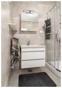 een badkamer met een witte wastafel en een douche bij Apartment Ballin in Primošten
