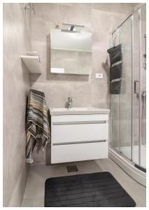 a bathroom with a white sink and a shower at Apartment Ballin in Primošten +6 photos