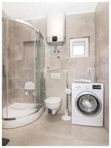 een badkamer met een douche, een toilet en een wasmachine bij Apartment Ballin in Primošten