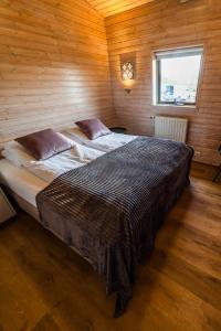 um quarto com uma cama grande num quarto de madeira em Efsti-Dalur Cottages em Úthlid
