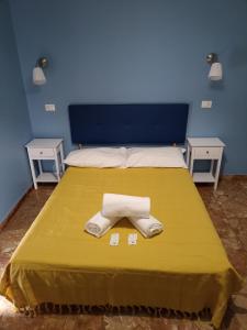 a bed with a yellow blanket with a towel on it at Affittacamere Novoli in Florence
