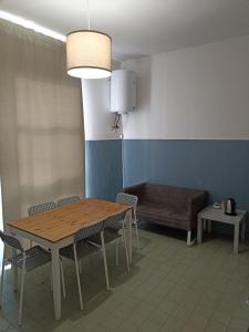 una camera con tavolo, sedie e divano di Affittacamere Novoli a Firenze
