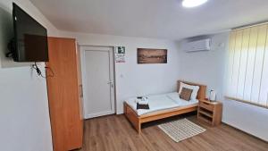 a room with a bed and a flat screen tv at Apartmani - Kladovski Konak in Kladovo