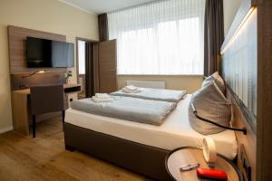 een hotelkamer met een bed, een bureau en een televisie bij Lieblingsquartier St. Andreasberg in Sankt Andreasberg