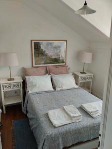 リスボンにあるMigas Lisbon Houseのベッドルーム1室(ベッド1台、テーブル2台、ランプ2つ付)