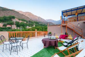 d'une terrasse avec des tables et des chaises sur un balcon avec des montagnes. dans l'établissement Smile House Imlil, à Imlil