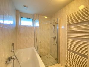 y baño con ducha, bañera y ducha. en Previnaireweg 24, en Callantsoog 13 fotos más