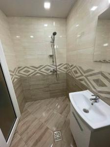 La salle de bains est pourvue d'une douche et d'un lavabo. dans l'établissement Cozy New Apt - Уютен апартамент, à Blagoevgrad