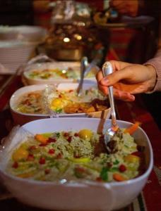 osoba jedząca miskę jedzenia na stole w obiekcie Wadi rum Rozana camp w mieście Wadi Rum