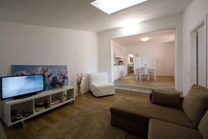 un salon avec un canapé et une télévision à écran plat dans l'établissement Scudaniglio Apartments, à Trapani