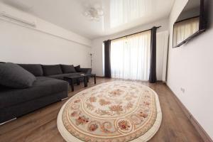 ein Wohnzimmer mit einer Couch und einem Teppich in der Unterkunft Aparthotel Mirage Sunset - zona Hotel Rex in Mamaia